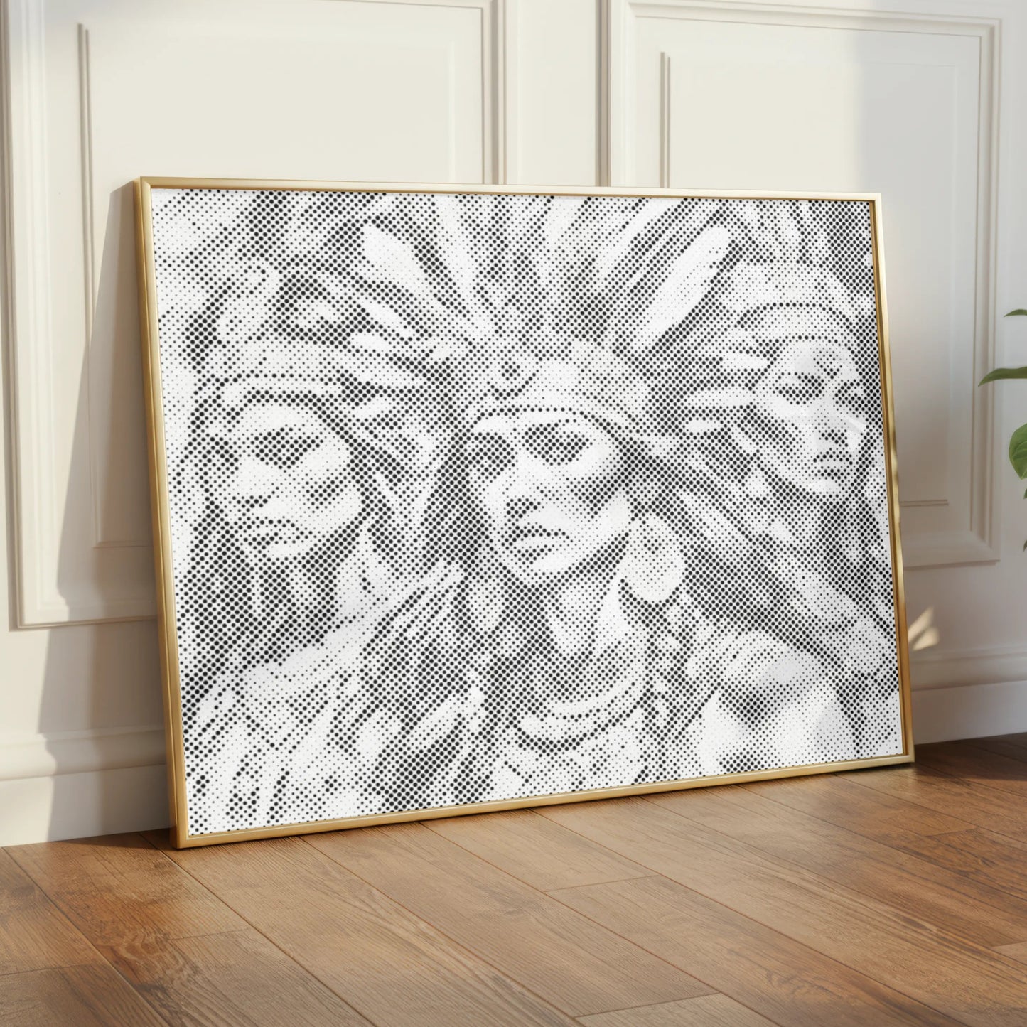 Framed artwork of a woman with a headdress on a wall in a room with wooden flooring and a plant.