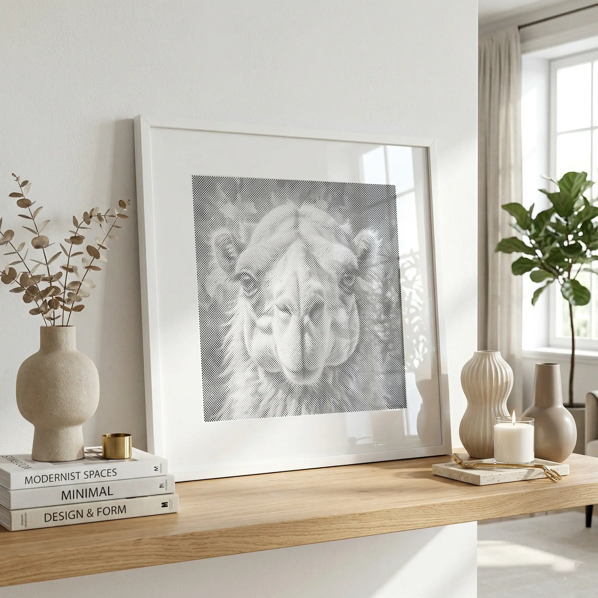 A framed black and white camel portrait print leaning on a light wood console table in a bright, modern room with neutral decor. Camel | Dot Painting Kit