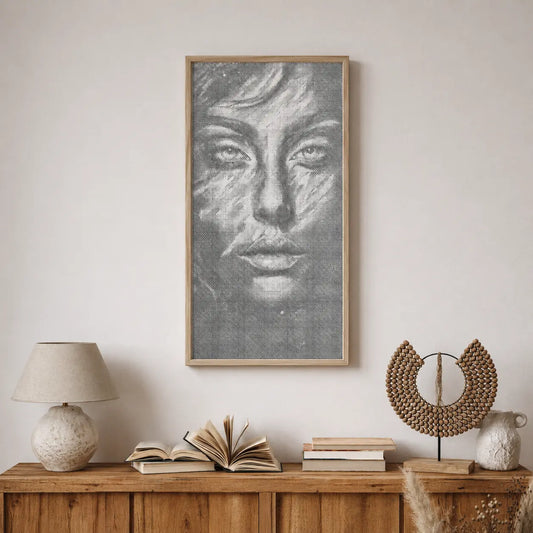 Framed artwork of a face on a wall above a wooden console table with books and decorative items. Face of Silence | Dot Painting Kit