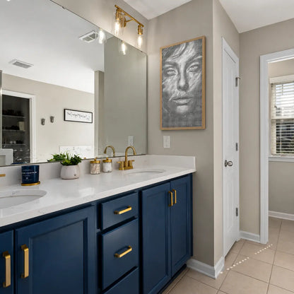 Bathroom with blue vanity, white countertop, and gold fixtures. Face of Silence | Dot Painting Kit