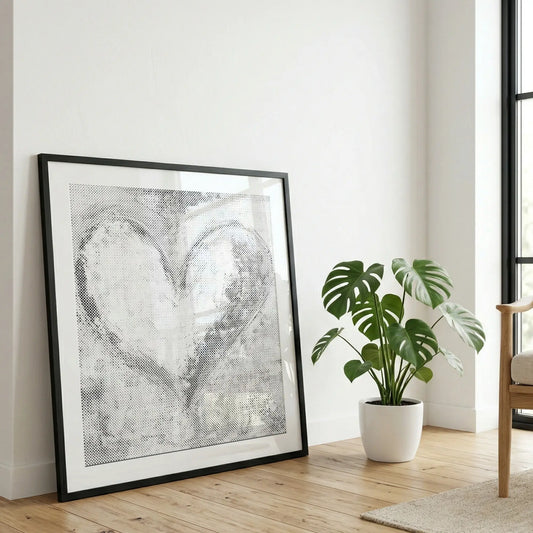 Framed paint dy dots dot painting on a wall with a plant in the foreground