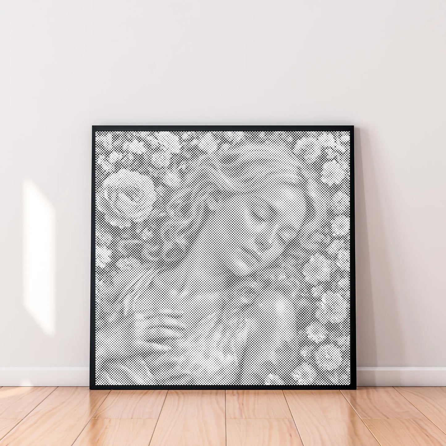 Framed artwork of a woman's face with floral patterns on a white wall.