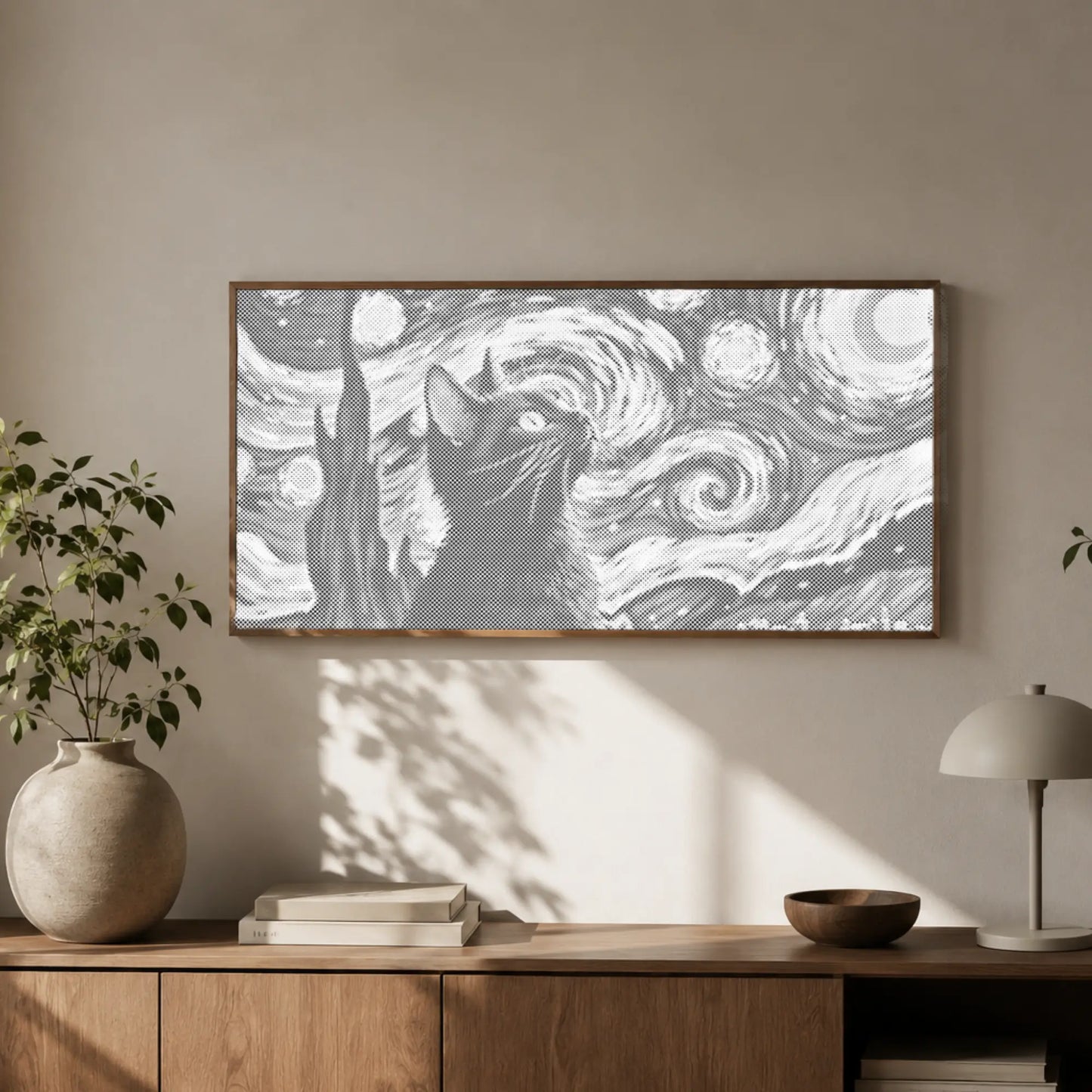 Framed artwork of a cat with a starry night design above a wooden cabinet.