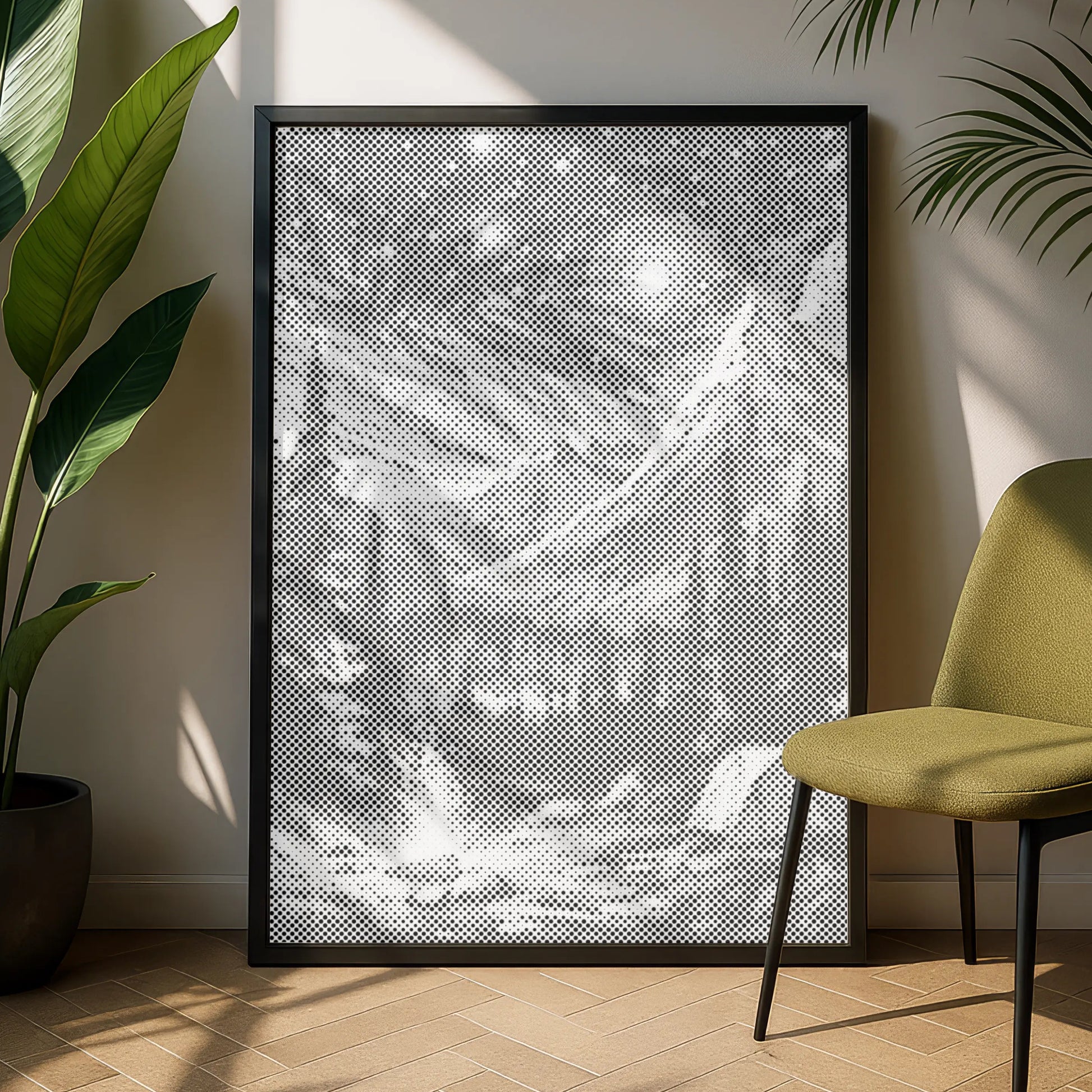 Framed artwork on a wall with a green chair and plant in a room. Dot painting 